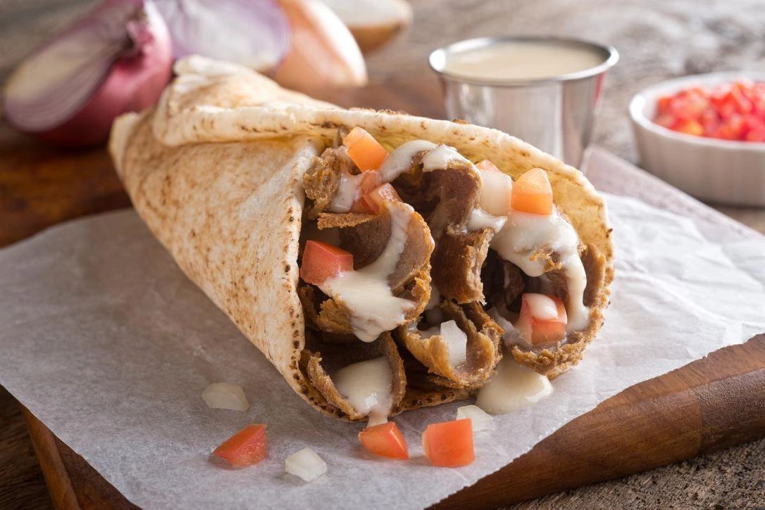 A Halifax-style beef donair with sweet garlic sauce, tomato and onion